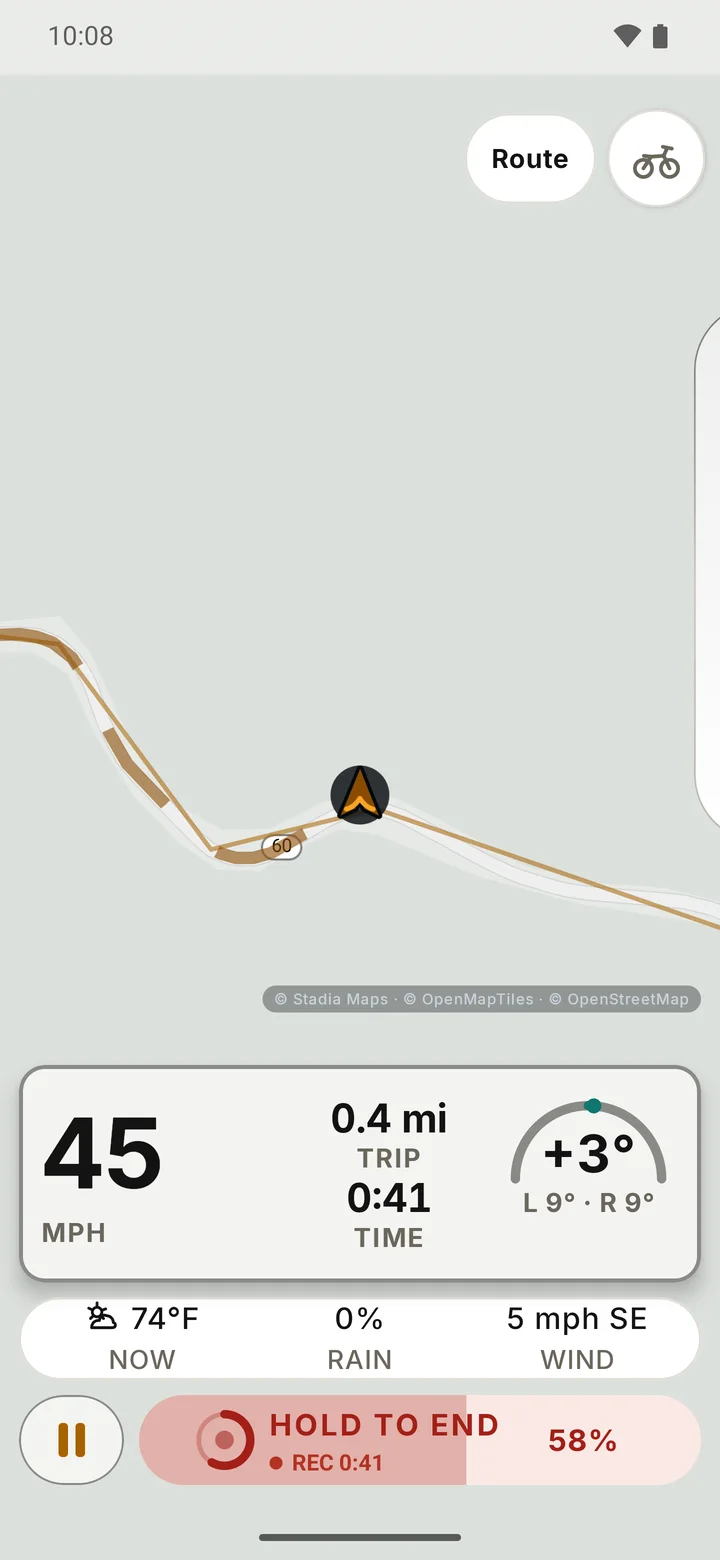 RIDE riding screen while Hold to end is held: the red end control is partly filled and reads 58 percent, with speed, trip, time, live lean and the weather strip still on screen.